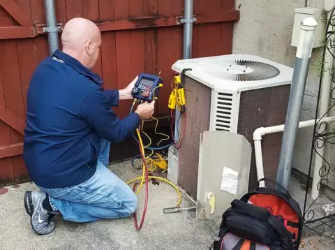 Matt Mathis, owner, works on a customer's HVAC unit